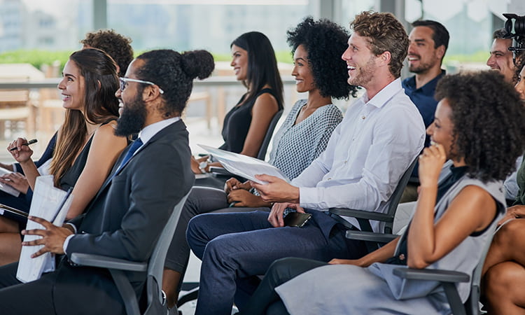 A conference crowd listens to a presentation